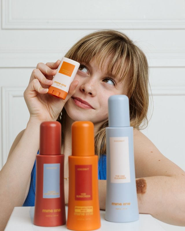 A model holding a skincare product with a colorful product collection